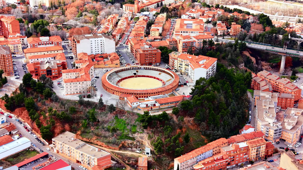 Ağaçlar ve konut apartmanlarıyla çevrili, kentsel bir ortamda yer alan yuvarlak boğa güreşi arenasının yüksekten havadan görünümü. İspanyol şehrinde dairesel bir boğa güreşi alanı.