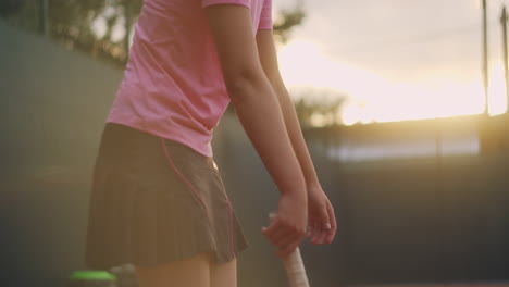 the woman stands bent to the waist after an intense tennis workout straightens up and breathes heavily