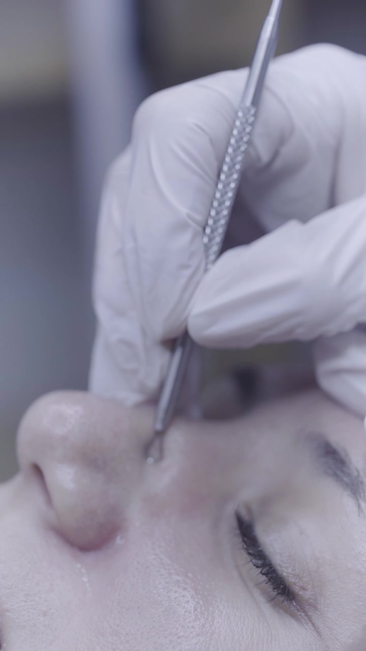 Ferramenta de metal precisa deslizando sobre o olho fechado durante tratamento facial