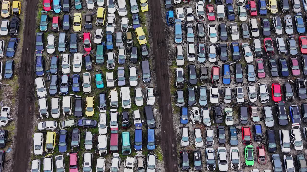 Parkeringsplads med mange biler parkeret i rækker og kolonner