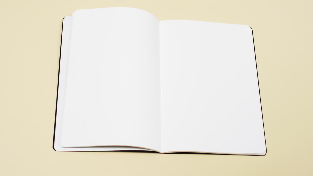 Video of book with white blank pages and copy space on yellow background
