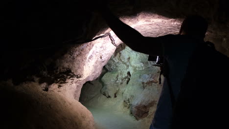 silhouette of a man exploring a cave with a torch man explores a cave silhouette of a man exploring a cave with a torch
