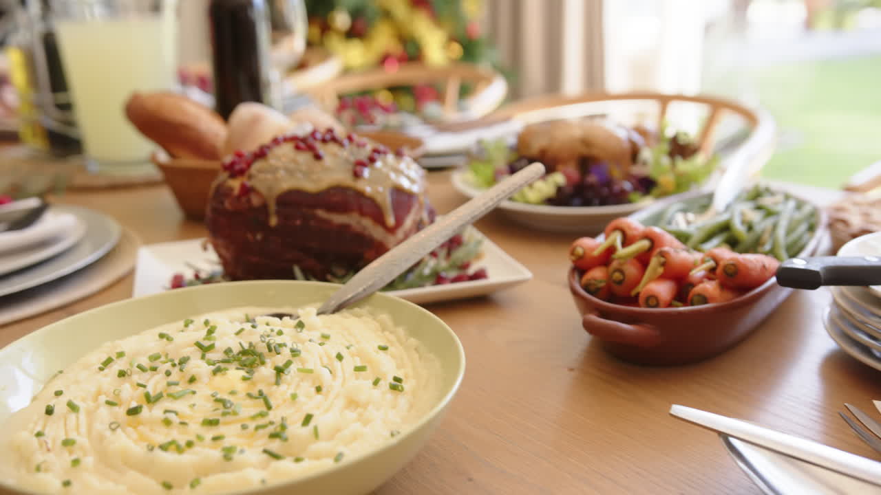 comida y bebida en la mesa de comedor puesta para la celebración de navidad comida, árbol en el fondo, cámara lenta