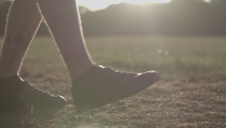 man stretching his legs before a run whilst being silhouetted by the evening sun in slow motion - ungraded