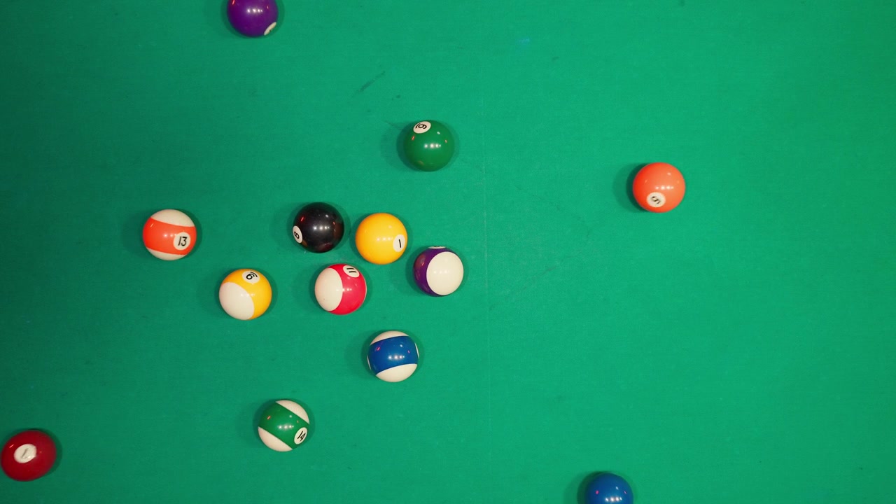Cue Ball Breaking Rack of Colorful Pool Balls on Green Table