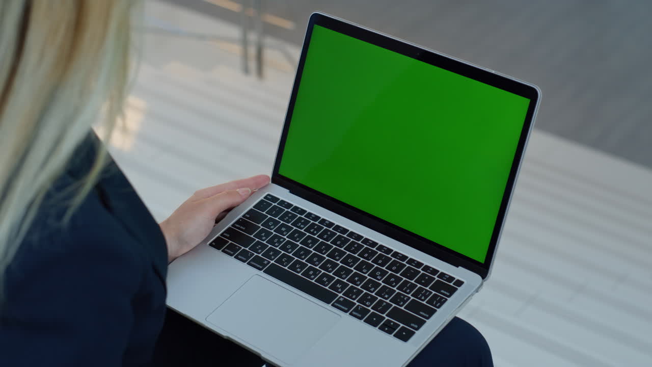 Primo piano di una donna d'affari che naviga su un portatile con chromakey in ufficio. Donna d'affari sconosciuta