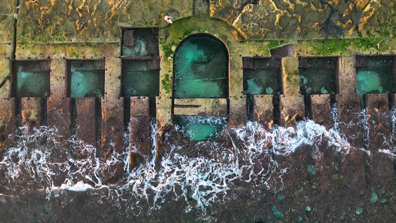 Woman Swimming at the Sliema Roman Sea Baths in Malta at Sunrise - Top Down Drone Shot