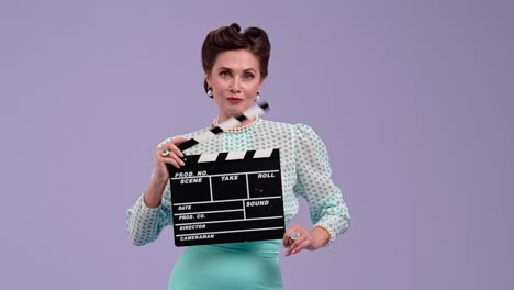 elegant woman holding a clapperboard