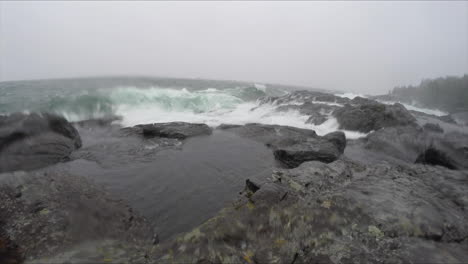 very large waves breaking on the rocky shoreline of lake superior in a winter storm