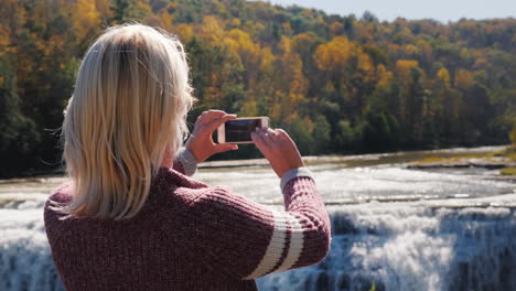 woman photographs genesee river waterfall