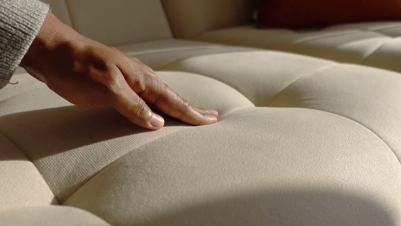 Close-up of a hand on a couch cushion
