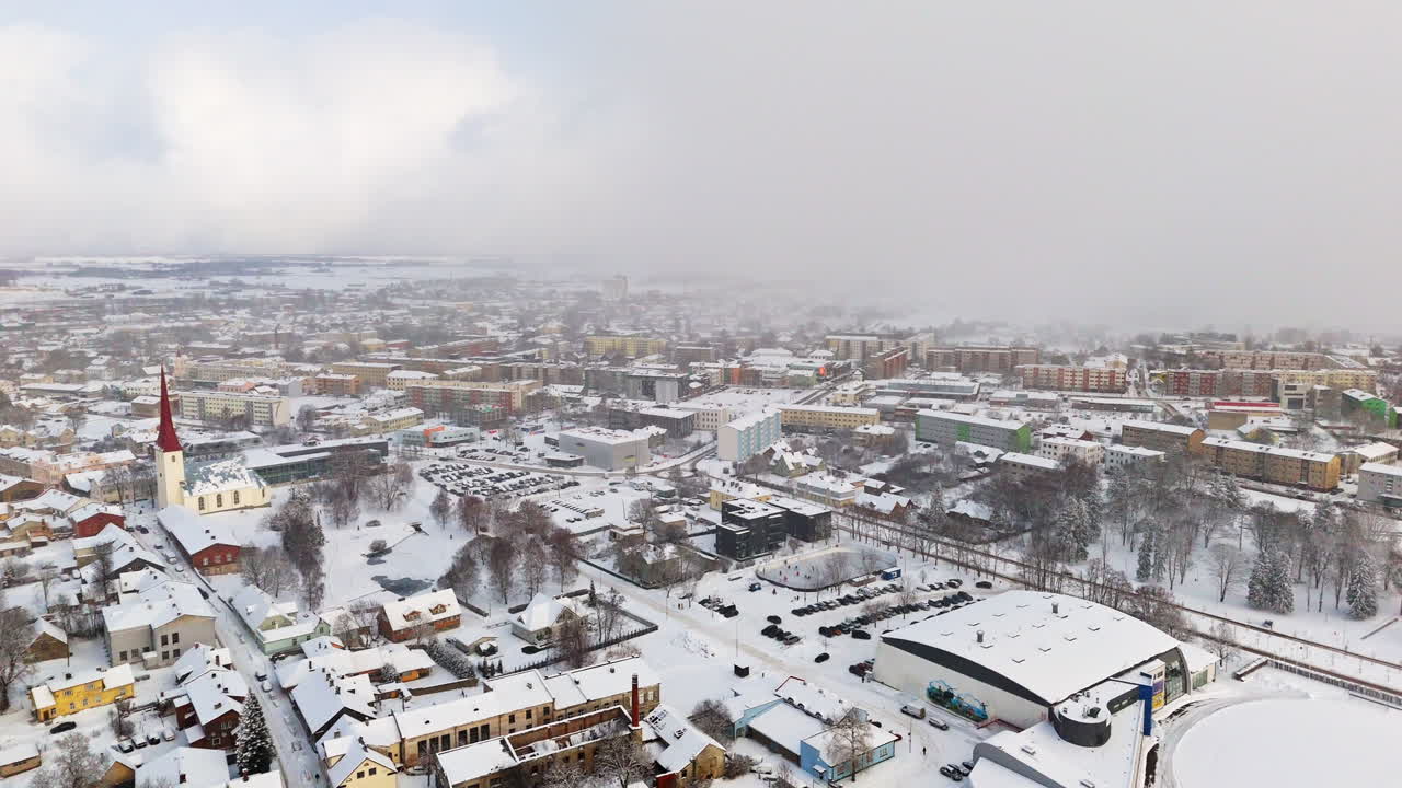 Panoramic drone shot circling the snowy cityscape, blizzard in Rakvere, Estonia