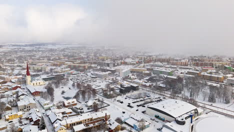 panoramic drone shot circling the snowy cityscape, blizzard in rakvere, estonia