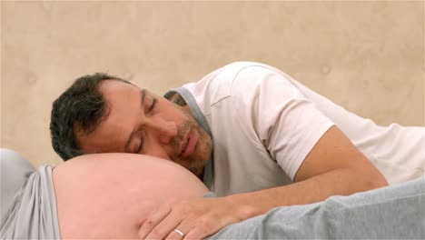 man sleeping on his pregnant wifes belly