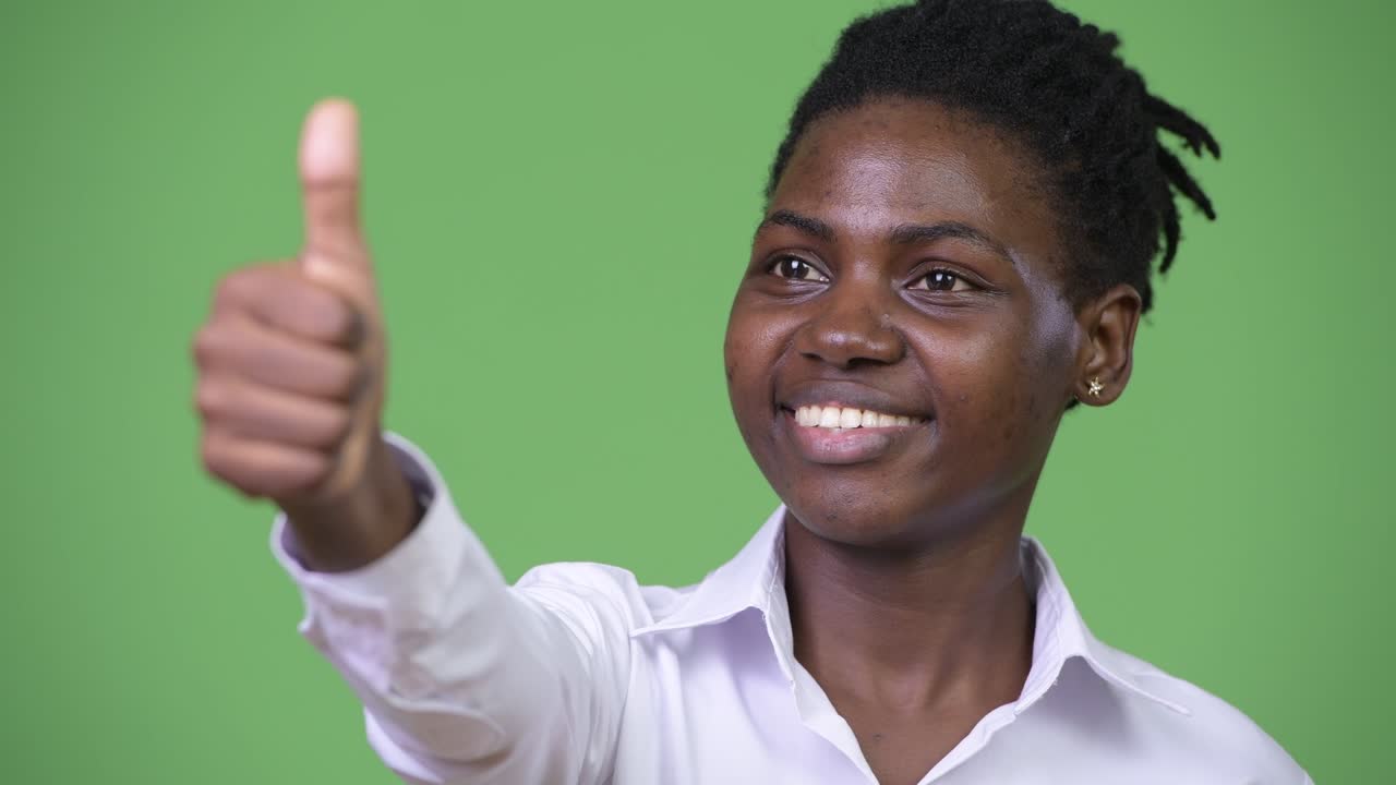 Giovane e bella donna d'affari africana che fa il gesto del pollice in su