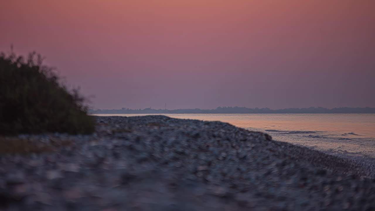 acera de ángulo bajo primer plano del amanecer sobre el océano, gradiente púrpura del cielo timelapse