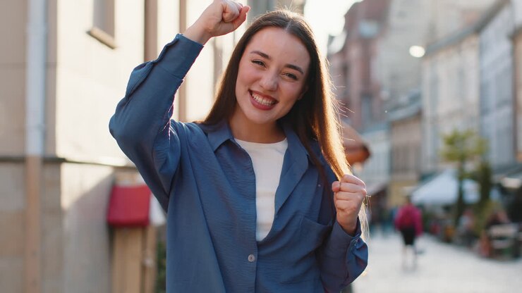 Giovane donna che grida festeggiando il successo il traguardo del traguardo della vittoria buone notizie di vittoria per la strada della città