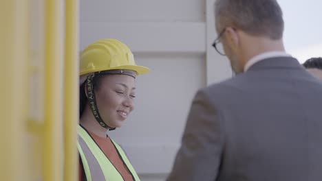 supervisor women and male engineer explain procedure and loading cargo process in the transport system to investor or executive, shake hands to express appreciation and pleasure to work together.