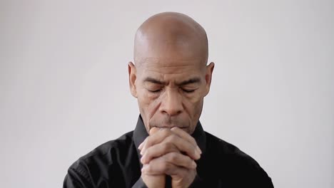 man-praying-to-god-with-hands-together-Caribbean-man-praying-with-black-background-with-people-stock-footage