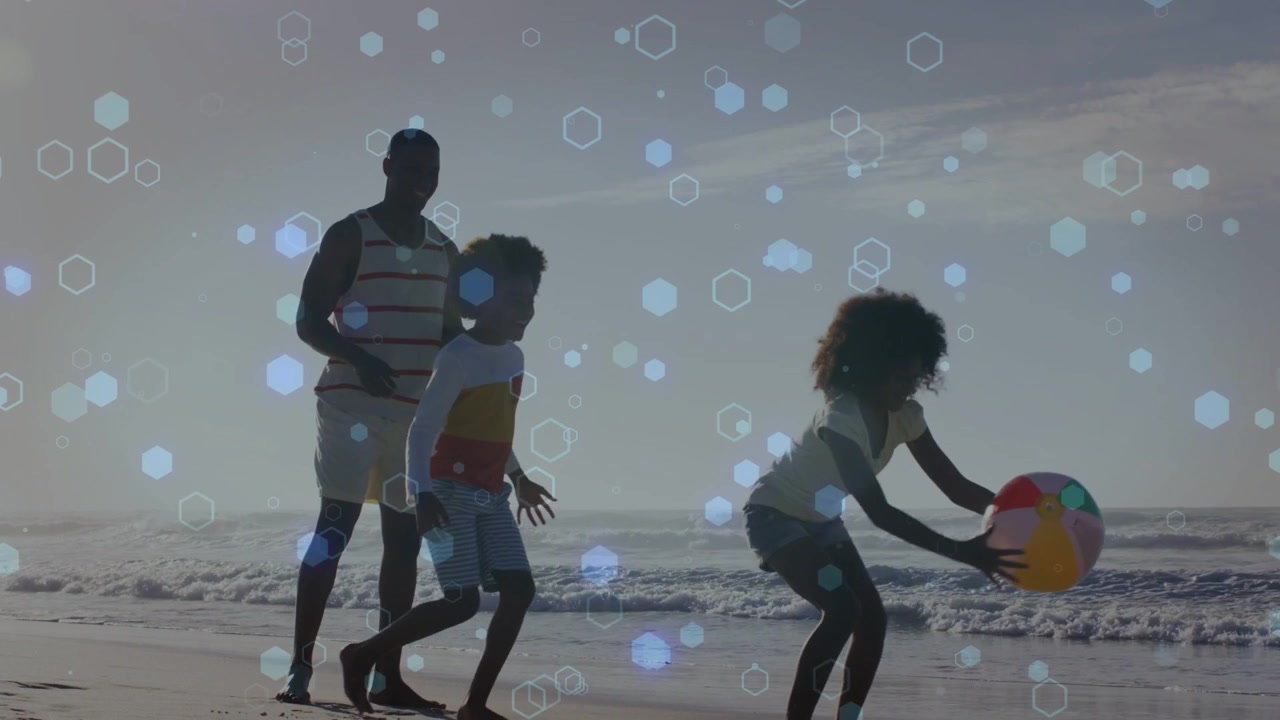 Father kids tossing beach ball on shore girl catching retrieving bokeh overlay moving family play
