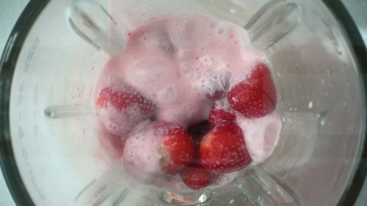 Preparation of strawberry in the blender with milk. Slow motion