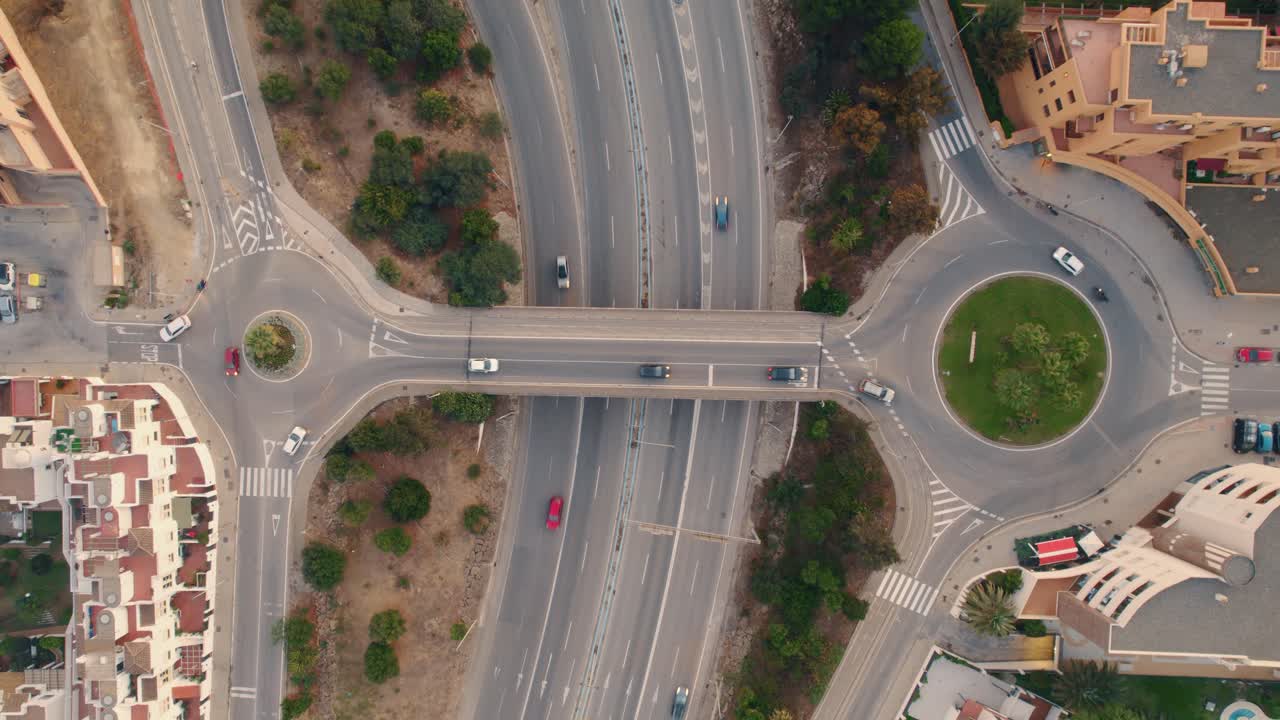 Aerial view directly above Spanish roundabout intersection over busy motorway route traffic
