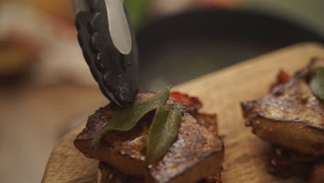 anonymous chef garnishing steak with bay leaves