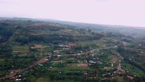 drone panoramic shot over kapchorwa, uganda, displaying a vast rural landscape with green hills, farmlands, and scattered homes, capturing the elevation and natural beauty of the region