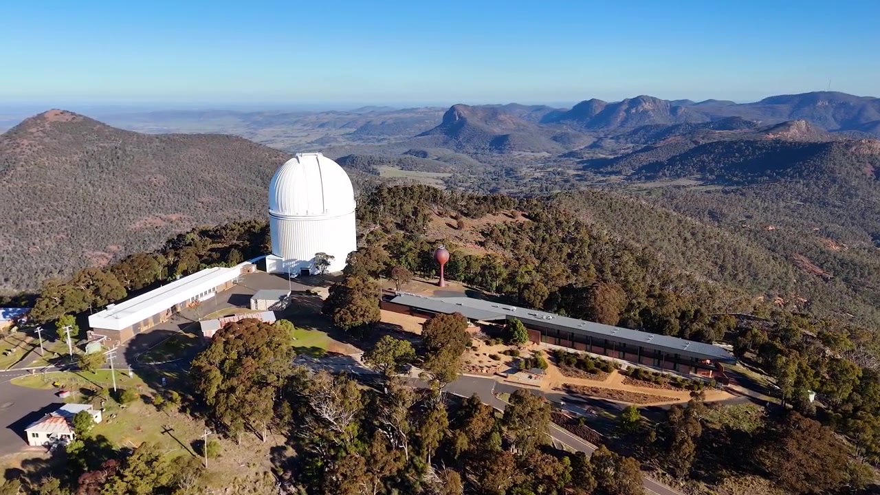 Ilmakuva dronella Siding Springin observatorion kupolista, josta avautuu näkymä vuorijonoille Uudessa Etelä-Walesissa.