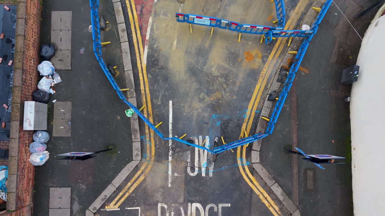 Drone si alza sopra le barriere stradali, rivelando una buca e un segnale di avviso di ponte basso