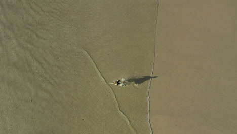 an unrecognizable man surfing at sunset