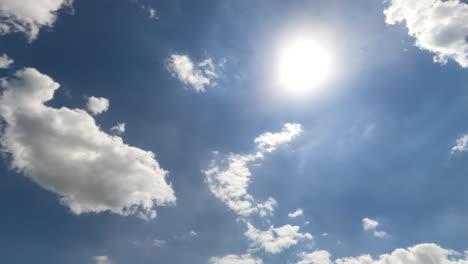 bright sunny summer day sky with light clouds. soft clouds covering sun from time to time. timelapse. view from below.
