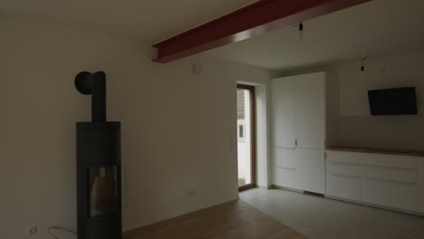 wide shot of a renovated midcentury house, modern feeling, steel beam separating kitchen and living room