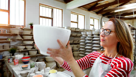 female potter checking bowl 4k