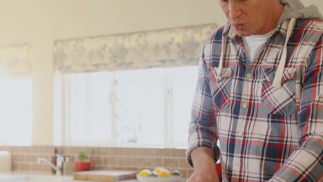 Mature-man-cutting-vegetables-in-kitchen-4k