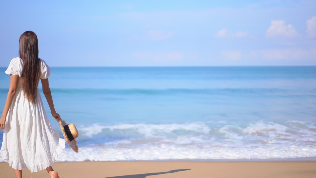 Happy Asian woman in white sundress walking on the white sand beach at ...