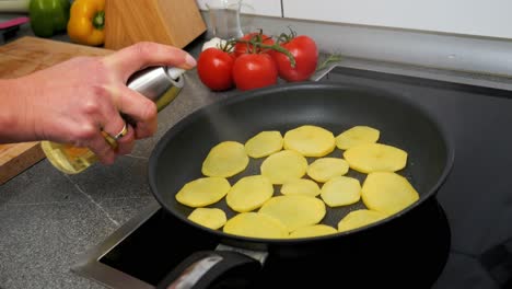 Rodajas-De-Patata-En-Una-Sartén-Rociada-Con-Aceite-De-Cocina