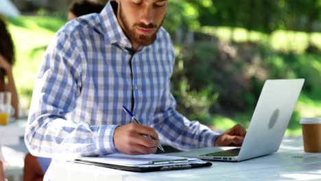 Man-writing-on-clipboard-at-restaurant