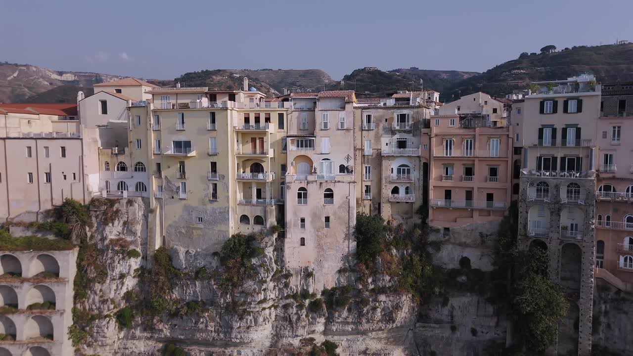Aerial Rise Revealing Cliffside Architecture and Rooftops in Tropea