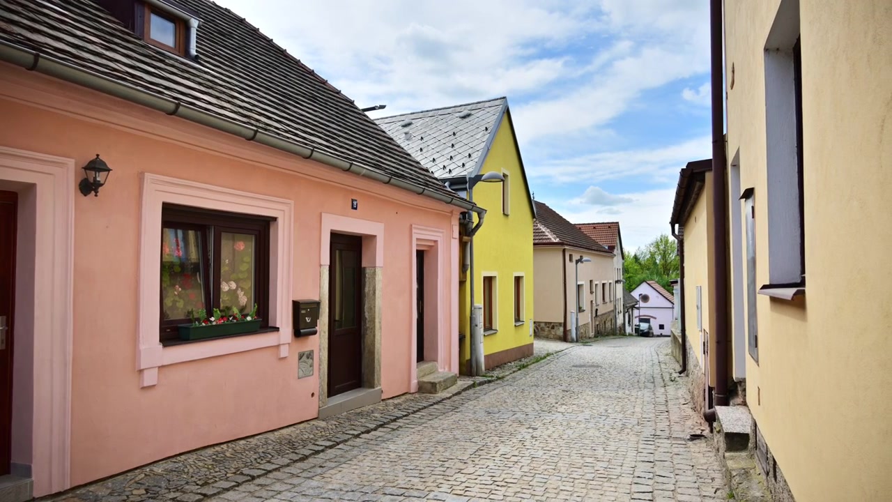 View of a quiet cobbled lane lined with small pastel houses, Vysocina, Czech Republic