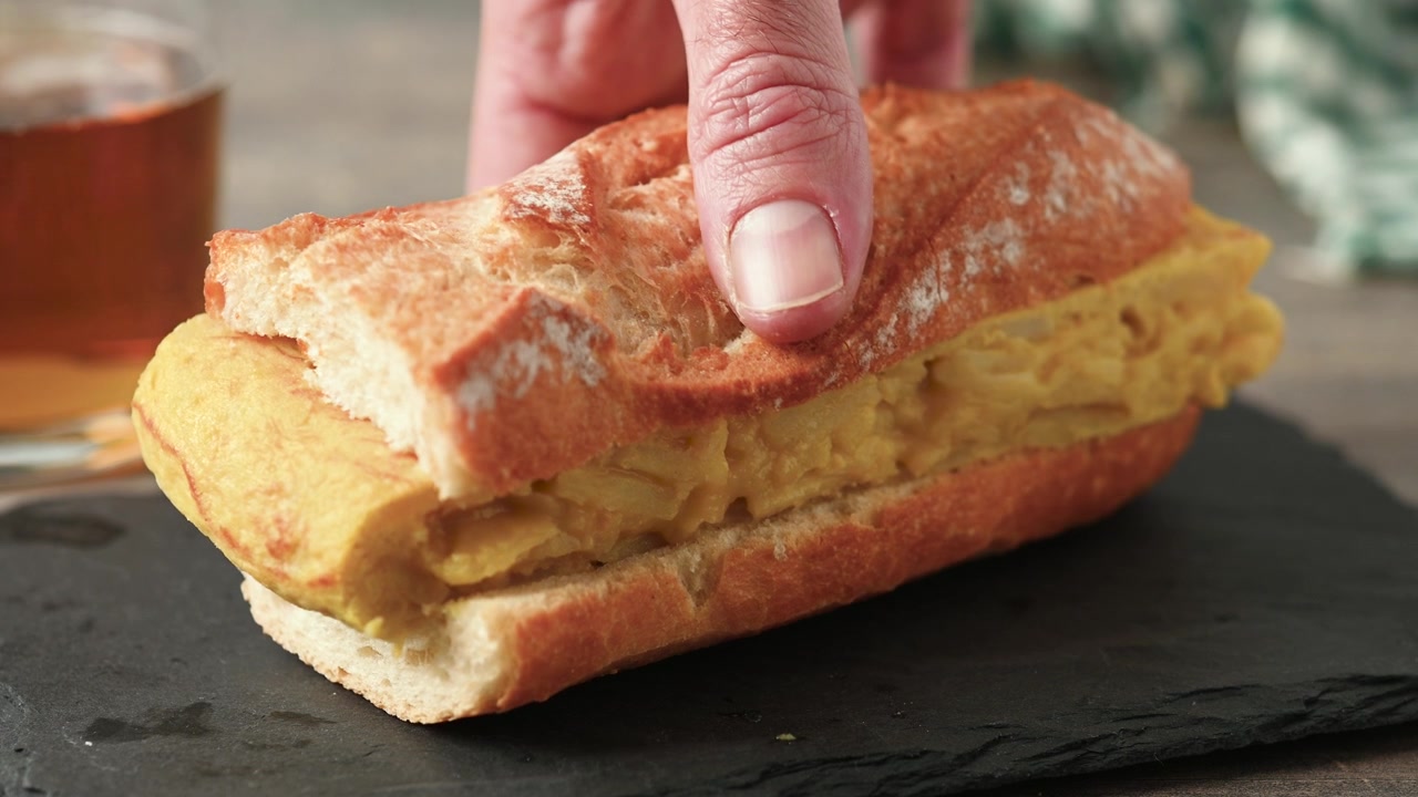 Panino con tortilla di patate spagnola su tavolo di legno. Bocadillo de tortilla