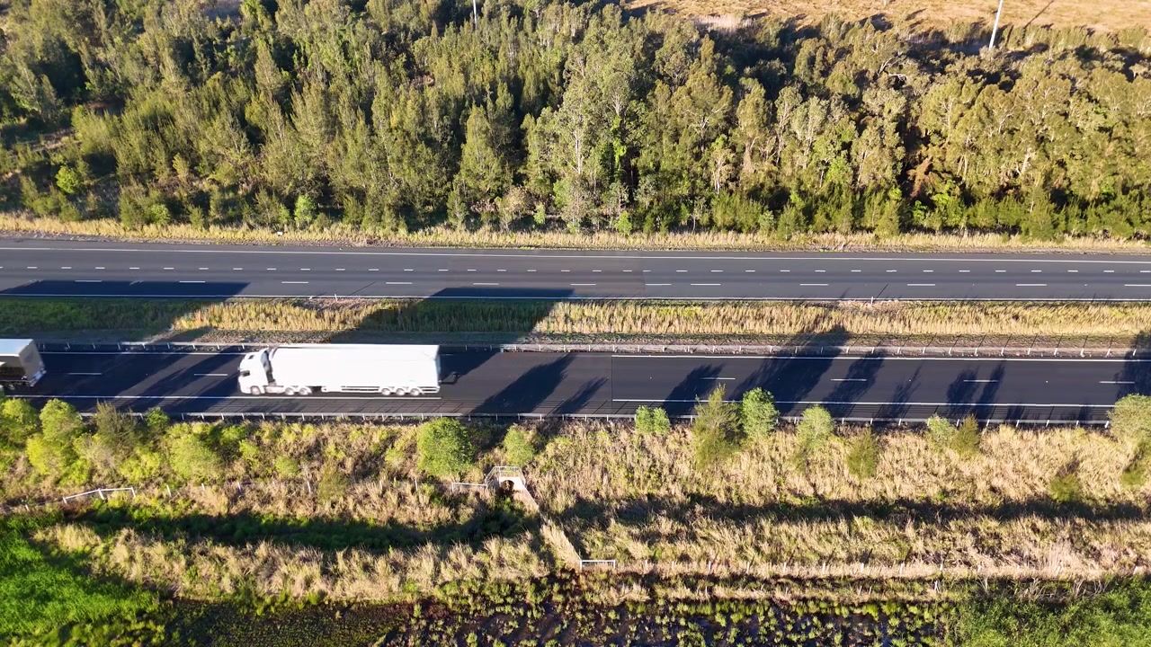 ニューサウスウェールズ州の田舎の高速道路を走行する車両の高角度空撮。