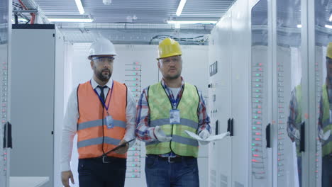 engineers reviewing documents in server room