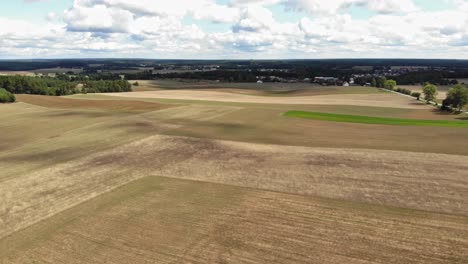 aerial high-altitude view of crop fields and a lakea in rural area of borowy młyn in kashubia, pomeranian voivodeship, poland