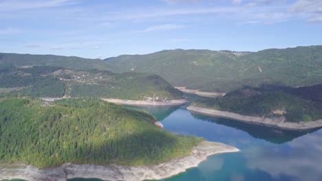 4k still static aerial shot of lake surrounded by green forest