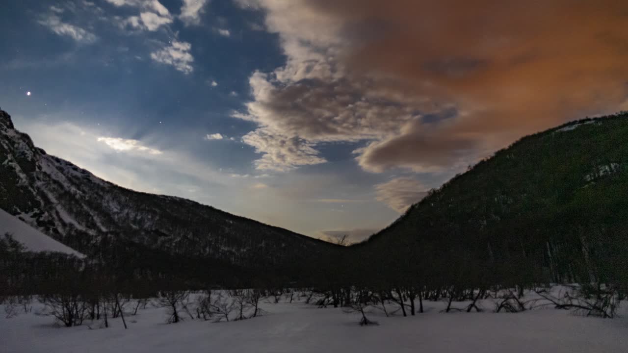 Timelapse di nuvole che passano su un cielo stellato all'alba sulla nevosa collina Hielo Azul, El Bolsón, Patagonia Argentina.