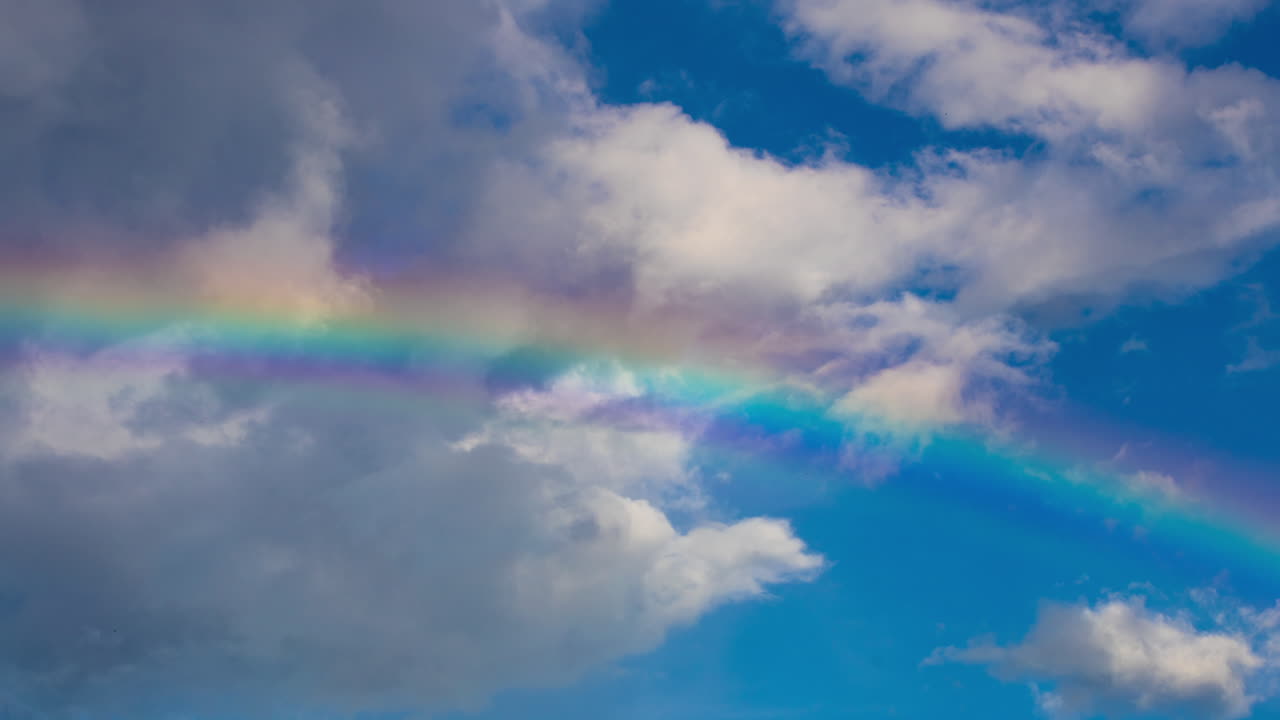 arco iris en el cielo con nubes en movimiento.