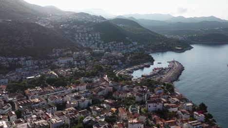 aerial panoramic overview of kas harbor in antalya, turkey, with boats docked along the marina and the coastal town spread across the hills