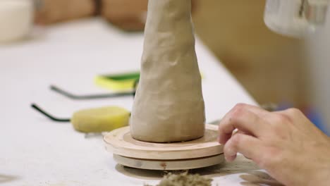 close up of ceramist working his artistic piece on wheel for ceramics