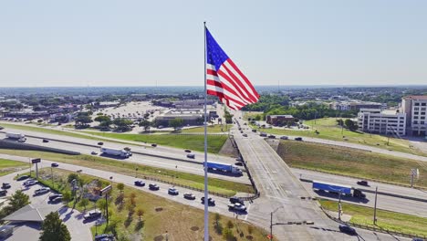 large american flag flying with interstate 30 in the background